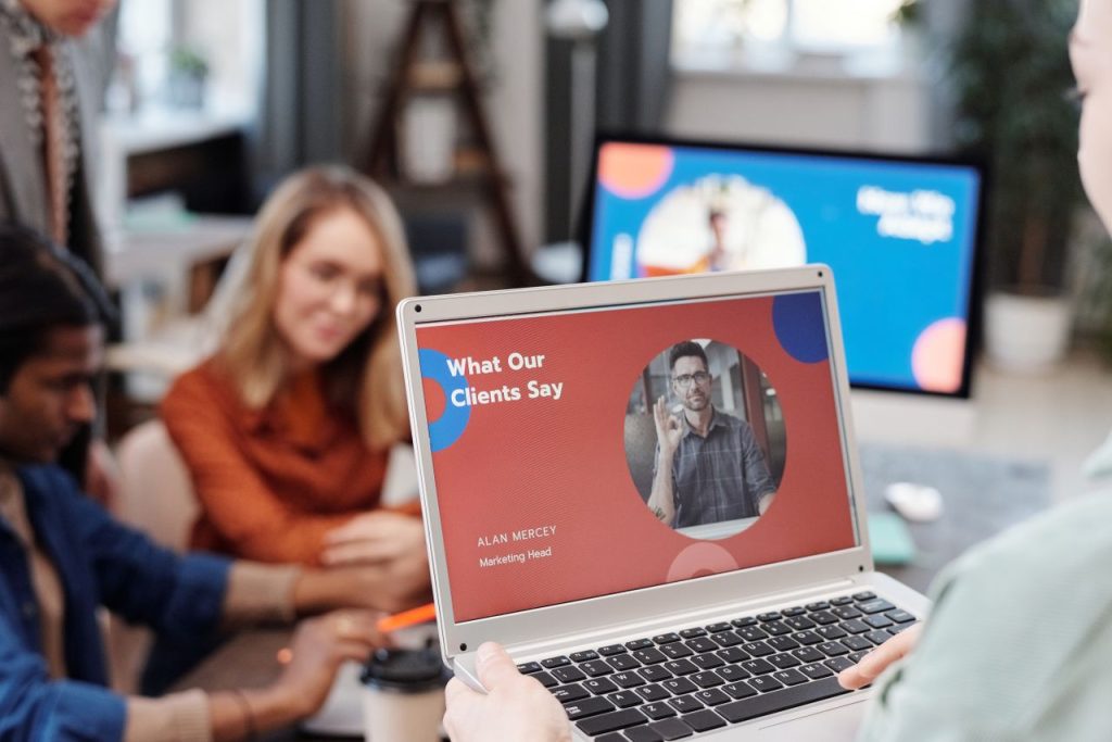 a-woman-using-a-laptop-at-work-6476253 Diverse business team in a meeting analyzing client testimonial on laptop screen.