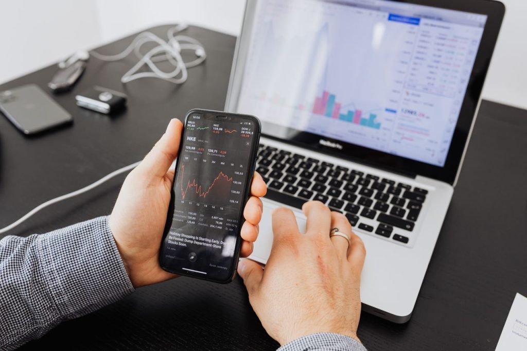stock-market-charts-on-phone-and-laptop-5717809 Person analyzes stock data with a smartphone and laptop, indoors.